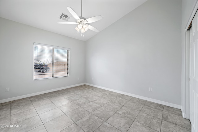 tiled spare room featuring ceiling fan and vaulted ceiling