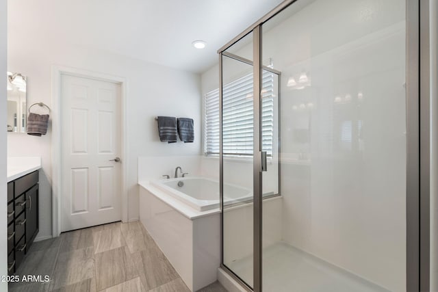 bathroom featuring vanity and independent shower and bath