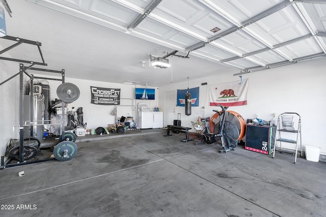 garage with a garage door opener and washing machine and clothes dryer