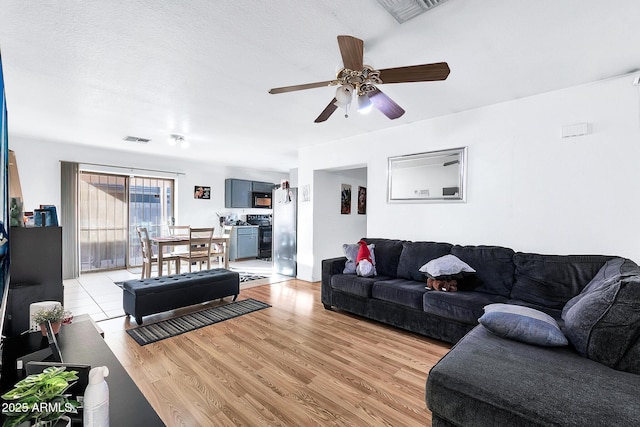 living room featuring light hardwood / wood-style flooring and ceiling fan