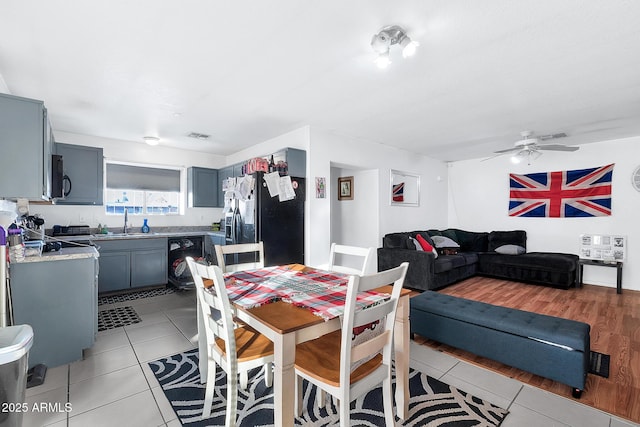 dining area with sink, light tile patterned floors, and ceiling fan