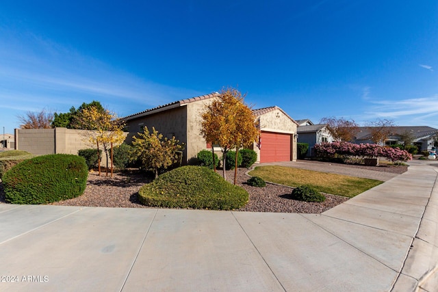 17966 W Highland Ave, Goodyear, AZ 85395 - view of side of home featuring stucco siding, fence, a tile roof, a garage, and driveway