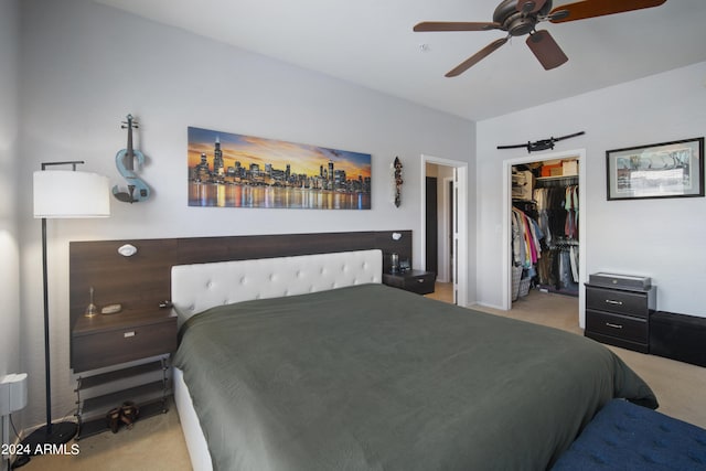 bedroom with a ceiling fan, a walk in closet, a closet, and light colored carpet