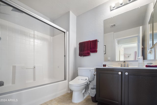 full bath with toilet, vanity, visible vents, combined bath / shower with glass door, and tile patterned floors