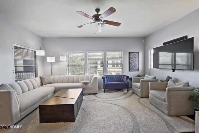 carpeted living room with ceiling fan