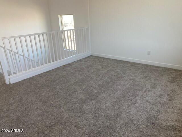 empty room with dark colored carpet