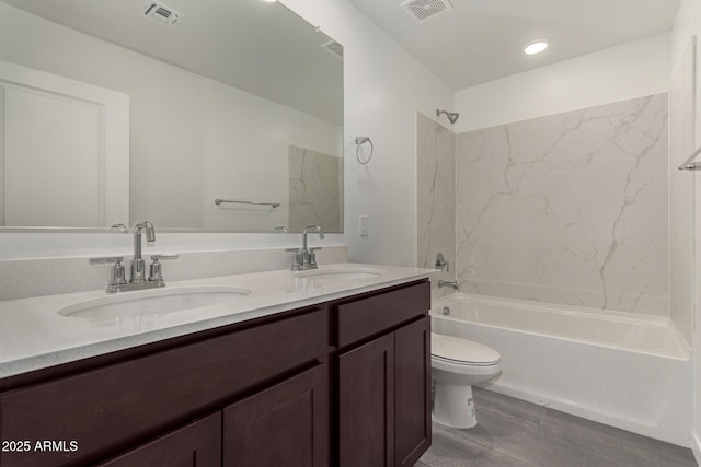 full bathroom featuring washtub / shower combination, vanity, and toilet