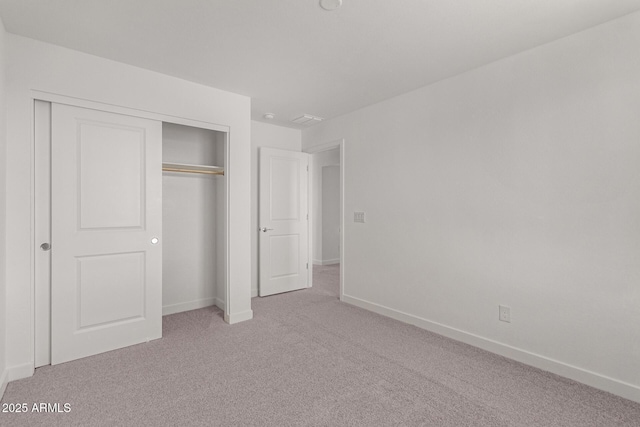 unfurnished bedroom featuring carpet flooring and a closet