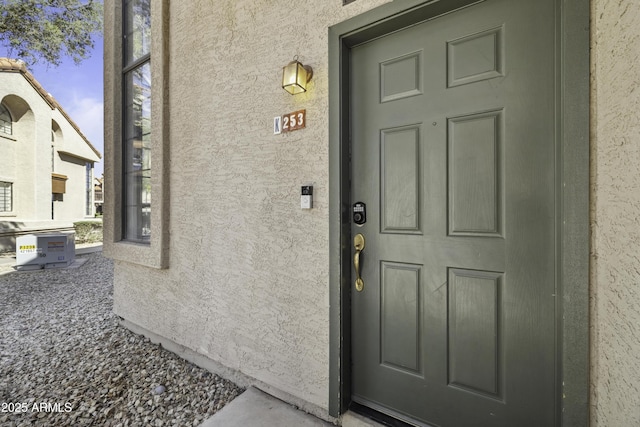 entrance to property featuring stucco siding