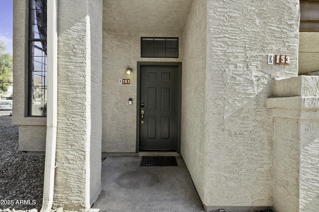 entrance to property with stucco siding