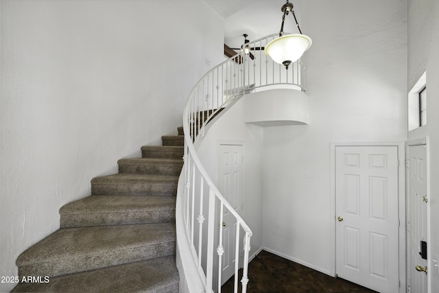 stairway featuring a towering ceiling