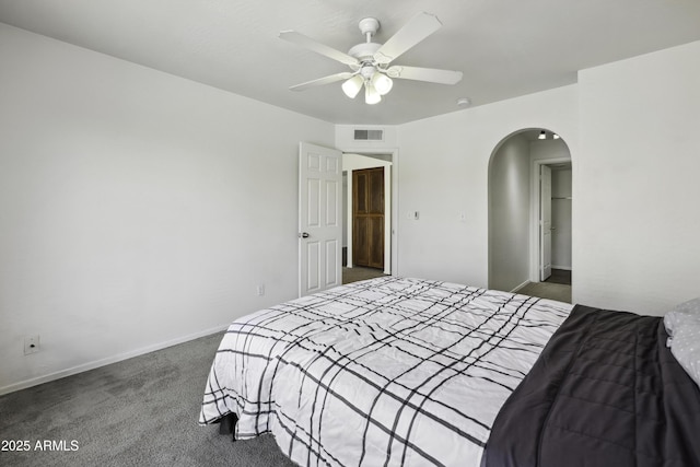 bedroom featuring visible vents, arched walkways, baseboards, ceiling fan, and carpet