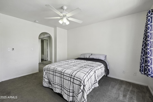 carpeted bedroom with arched walkways, ceiling fan, and baseboards