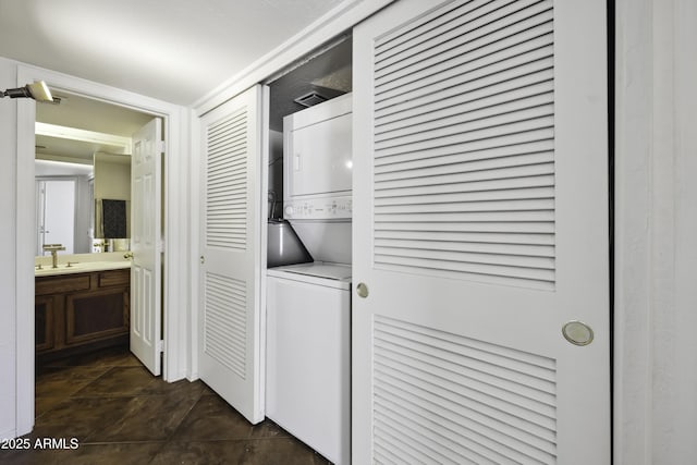 laundry area with stacked washer and dryer, laundry area, and a sink