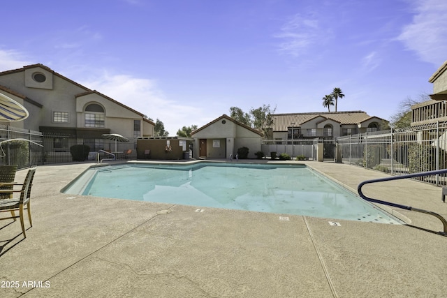 pool with a patio area and fence