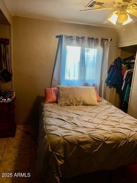 bedroom with ceiling fan, visible vents, and tile patterned flooring