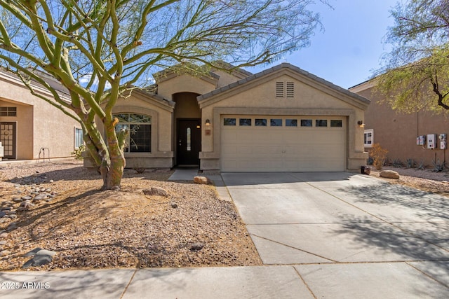 view of front of property with concrete driveway, a tiled roof, an attached garage, and stucco siding