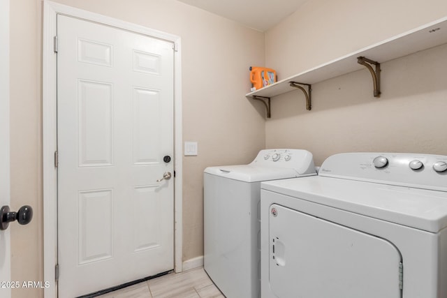 laundry area with laundry area, separate washer and dryer, and baseboards