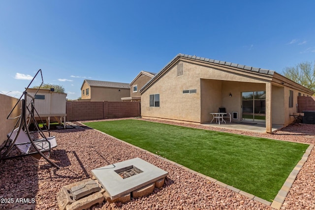 back of house featuring an outdoor fire pit, a patio area, a fenced backyard, and stucco siding