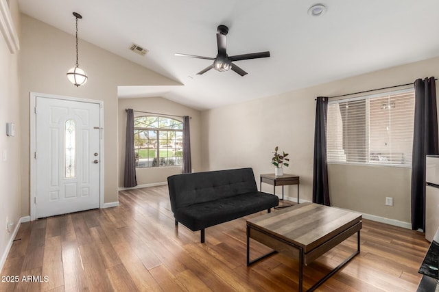 foyer with baseboards, visible vents, ceiling fan, wood finished floors, and vaulted ceiling