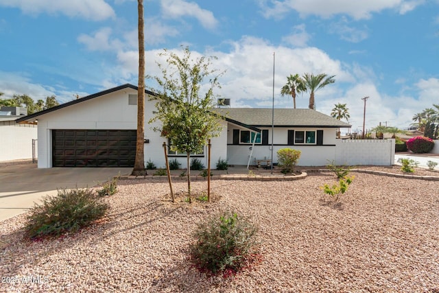 ranch-style house with a garage, driveway, and fence