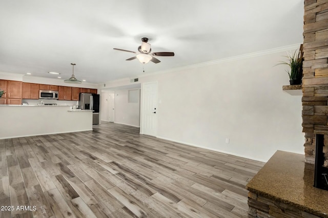 unfurnished living room featuring ceiling fan, baseboards, light wood-type flooring, and ornamental molding