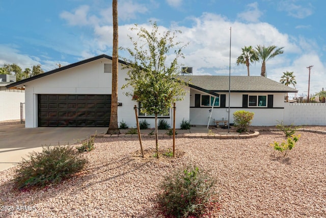 ranch-style home with a garage, brick siding, driveway, and fence