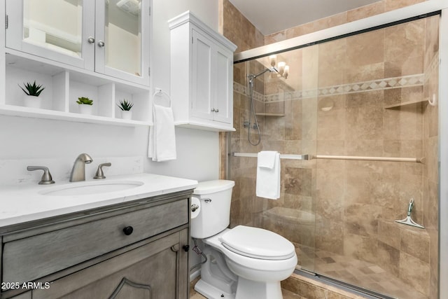 bathroom featuring a stall shower, toilet, and vanity