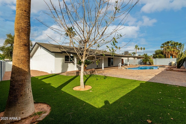 back of house featuring a patio, a lawn, and a fenced backyard