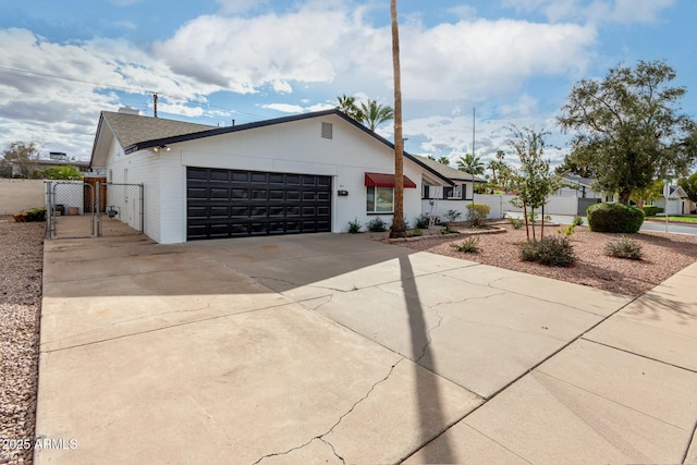 view of front facade with a gate, fence, a garage, and driveway