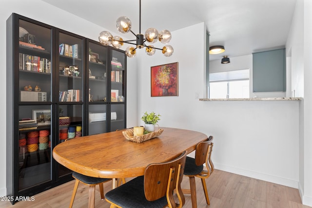 dining space with a chandelier and light hardwood / wood-style flooring