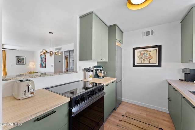 kitchen featuring decorative light fixtures, black range with electric cooktop, light hardwood / wood-style floors, a chandelier, and green cabinets