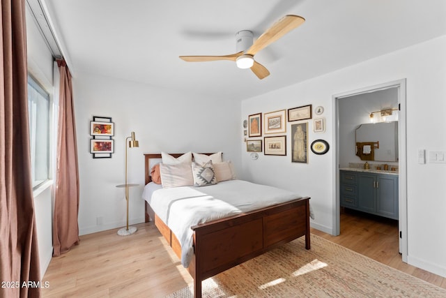 bedroom featuring ceiling fan, light hardwood / wood-style floors, and connected bathroom