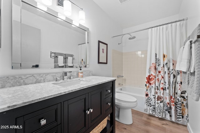 full bathroom featuring toilet, vanity, wood-type flooring, and shower / bath combo