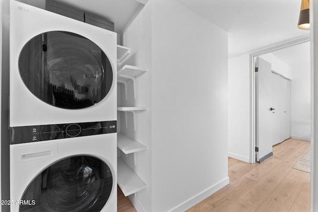 washroom featuring stacked washer / dryer and light wood-type flooring