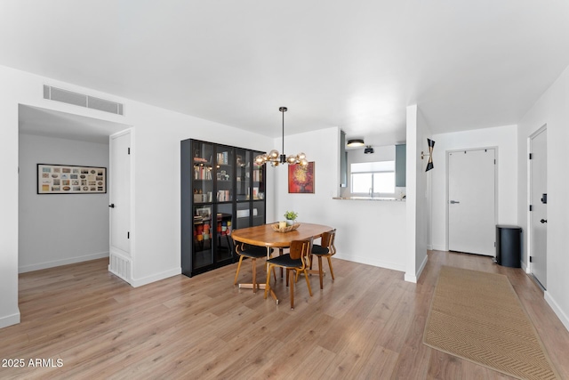 dining space featuring a chandelier and light hardwood / wood-style flooring