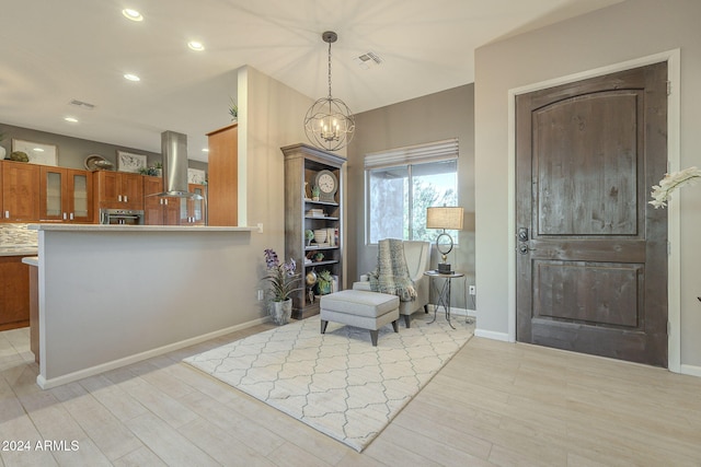 sitting room featuring a chandelier and light wood-type flooring