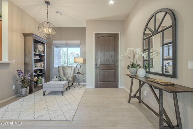 foyer with light hardwood / wood-style floors and a notable chandelier