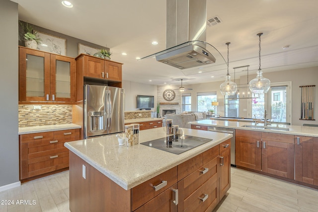 kitchen with sink, stainless steel appliances, tasteful backsplash, decorative light fixtures, and a kitchen island