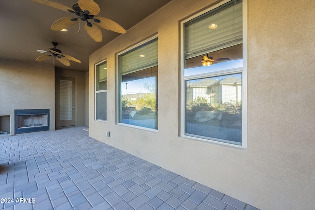 view of patio with ceiling fan and an outdoor fireplace