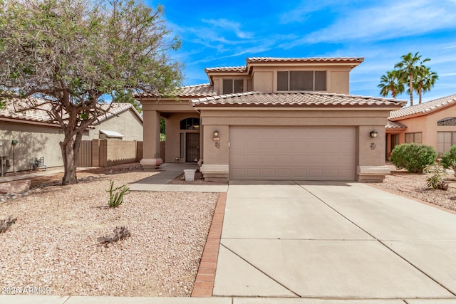 mediterranean / spanish-style home with fence, stucco siding, a tiled roof, concrete driveway, and an attached garage