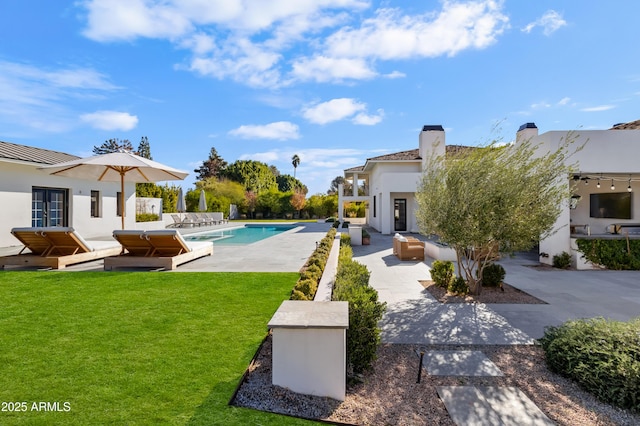 view of swimming pool with a lawn and a patio