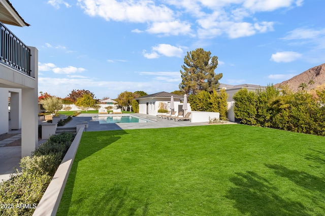 view of yard featuring a balcony, a fenced in pool, and a patio