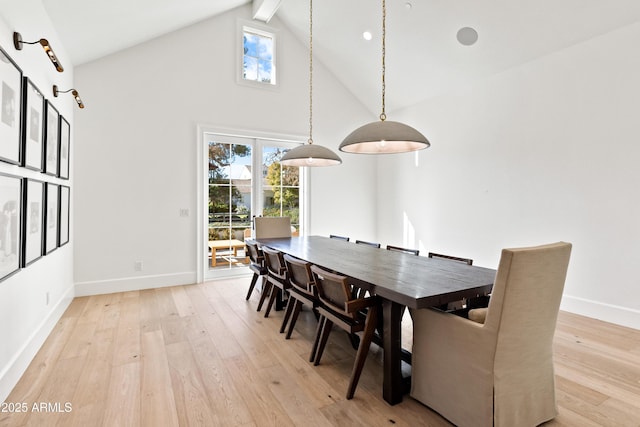 dining area with light wood-type flooring, high vaulted ceiling, and beamed ceiling