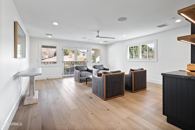 living room featuring ceiling fan, a wealth of natural light, and light hardwood / wood-style floors