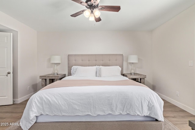 bedroom featuring wood finished floors, baseboards, and ceiling fan