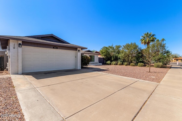 view of home's exterior with a garage, brick siding, and driveway