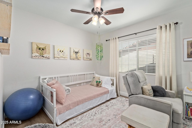 bedroom featuring ceiling fan, baseboards, and wood finished floors