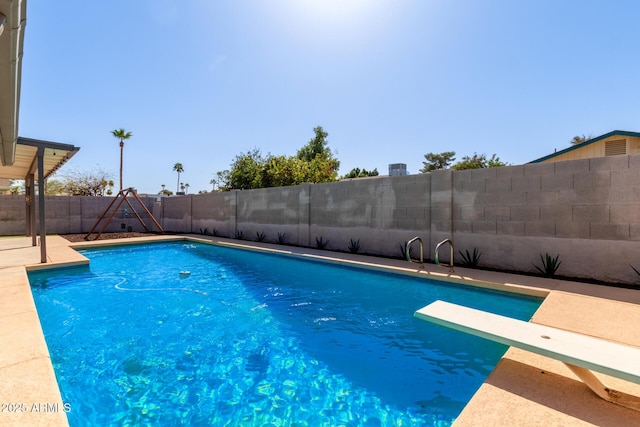 view of swimming pool featuring a fenced in pool, a fenced backyard, and a diving board