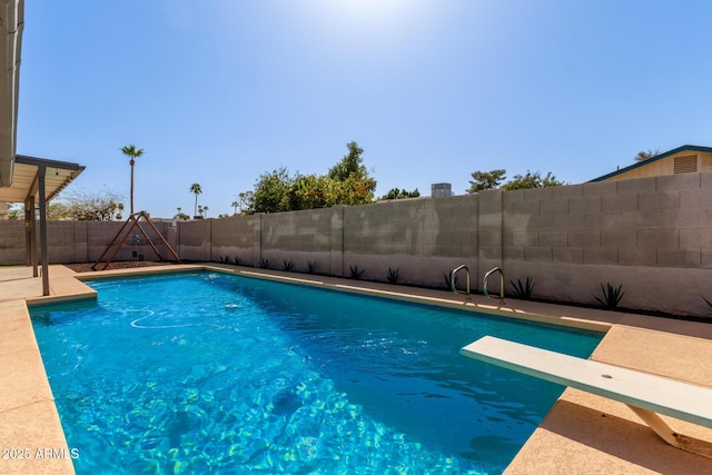 view of pool with a diving board, a fenced in pool, and a fenced backyard